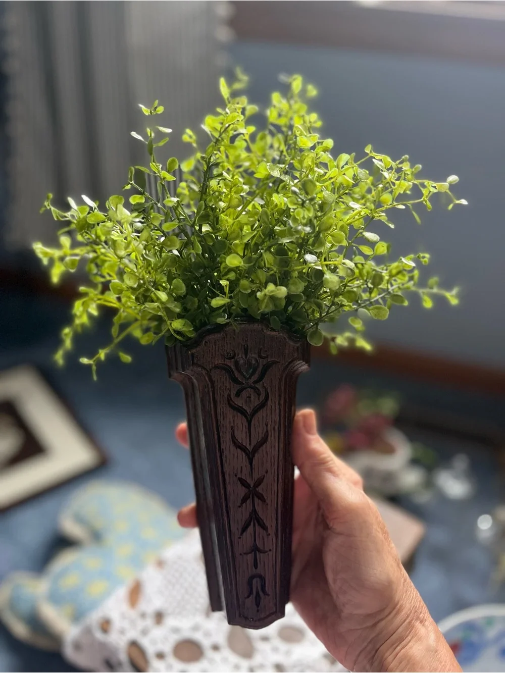 Carved Dark Wood Wall Pocket Vase will include a sprig of greenery